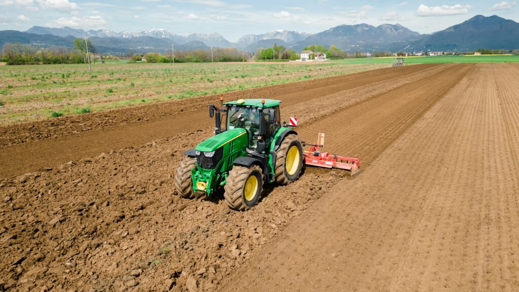 A picture of a rural farming community showcasing the use of farming machinery and equipment, such